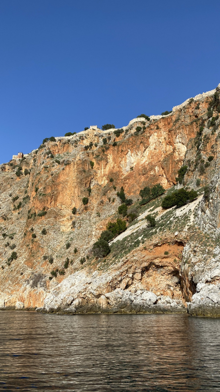 Обои обрыв, вода, гора, коренная порода, озеро в разрешении 750x1334