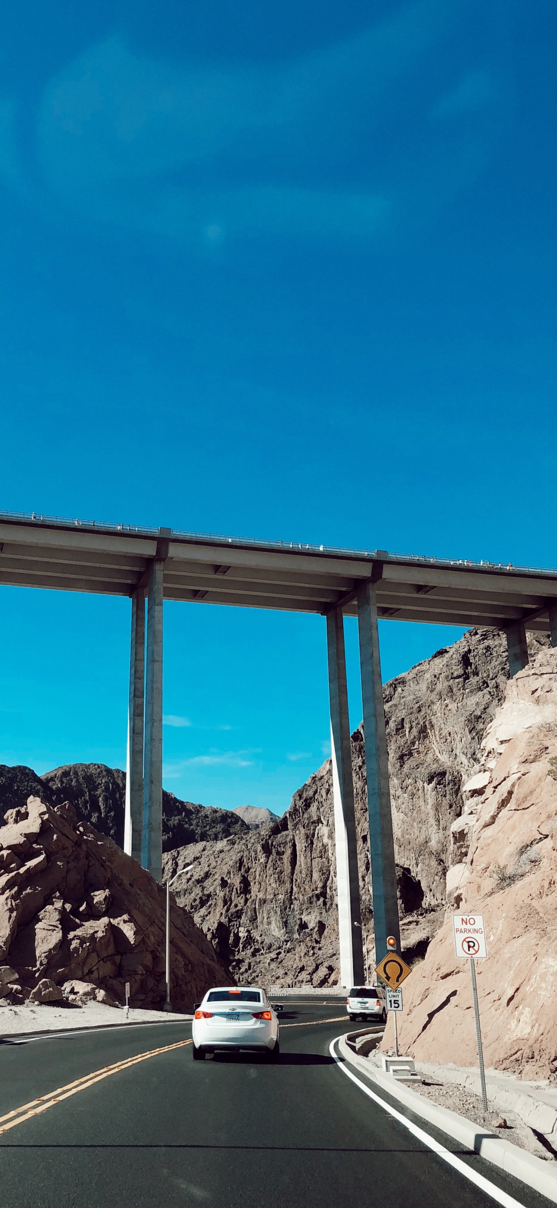 Обои дорога, дорожное покрытие, горный рельеф, инфраструктура, магистраль в разрешении 1125x2436