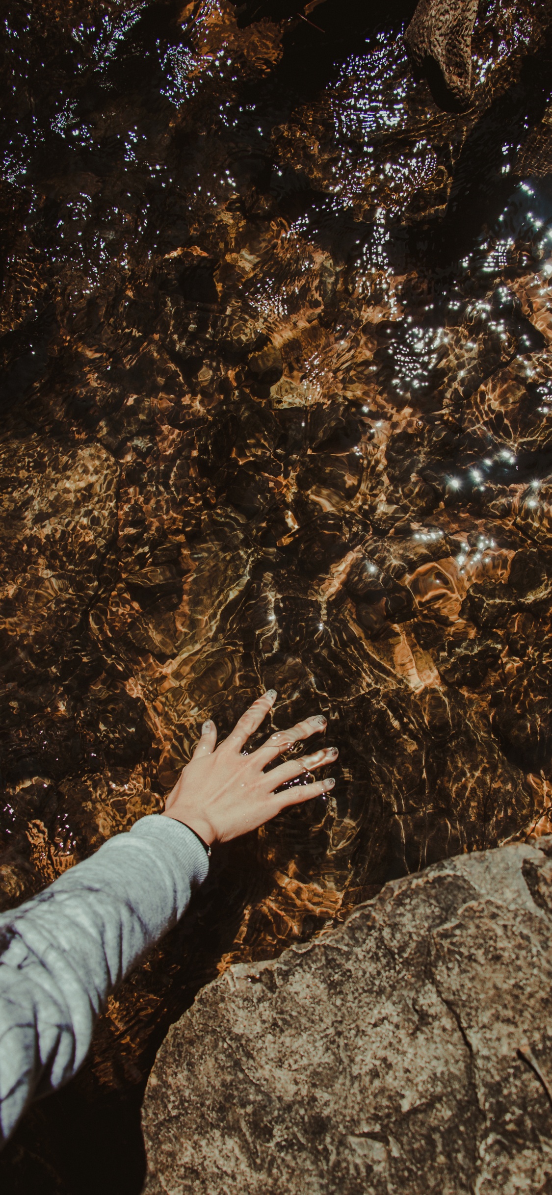 Обои человек касаясь скалы, рок, коричневый цвет, геология, дерево в разрешении 1125x2436