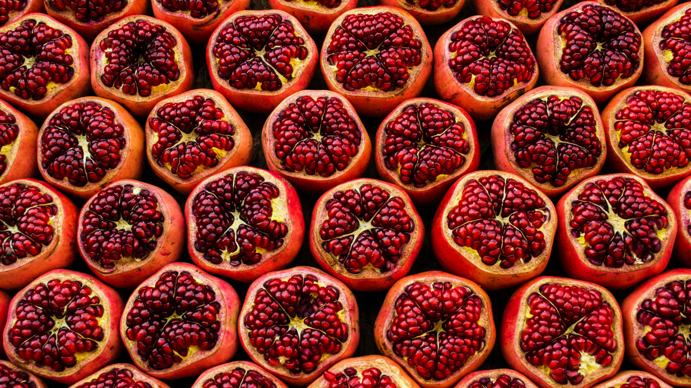 Обои Свежие гранаты разрезанные пополам в разрешении 1366x768