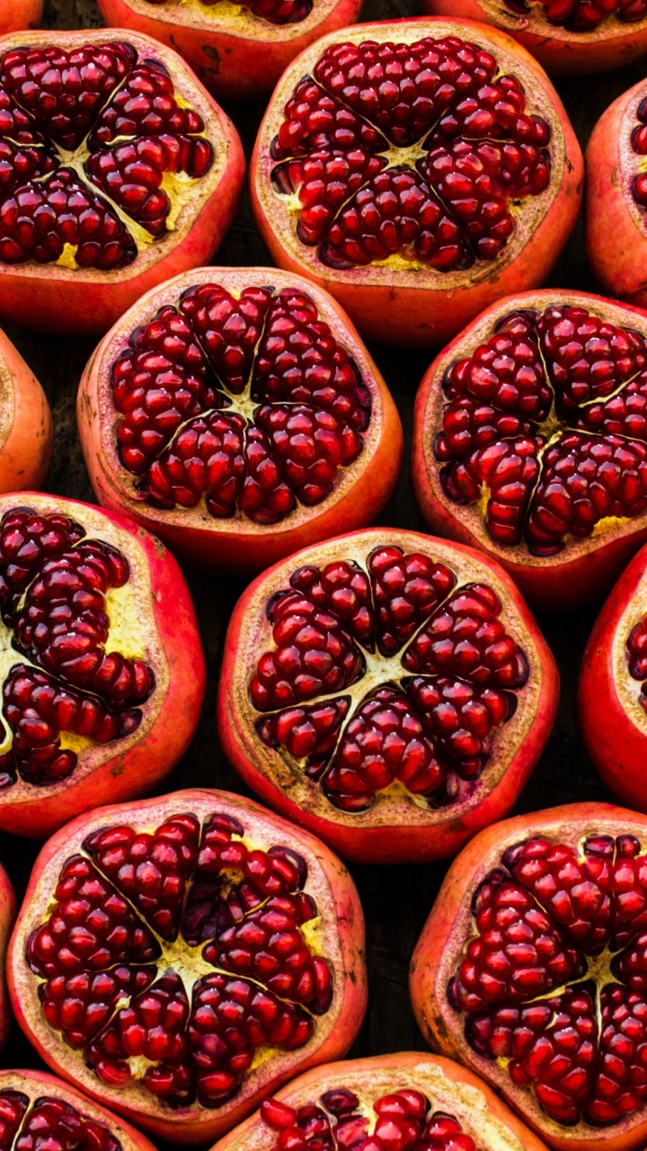 Обои Свежие гранаты разрезанные пополам в разрешении 720x1280